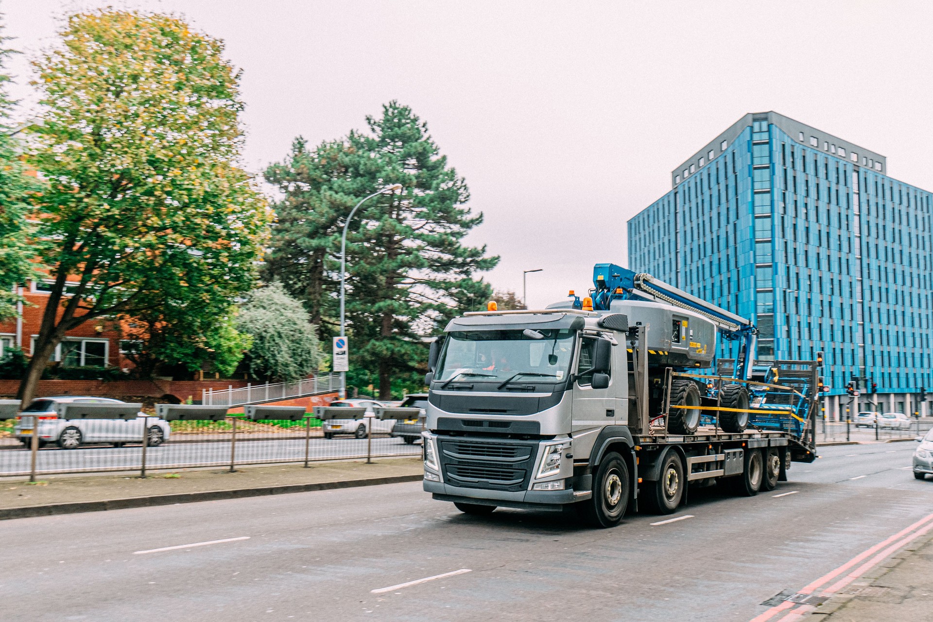 Cabover-Style Semi Truck Driving Delivering a Mobile Crane in Birmingham, UK
